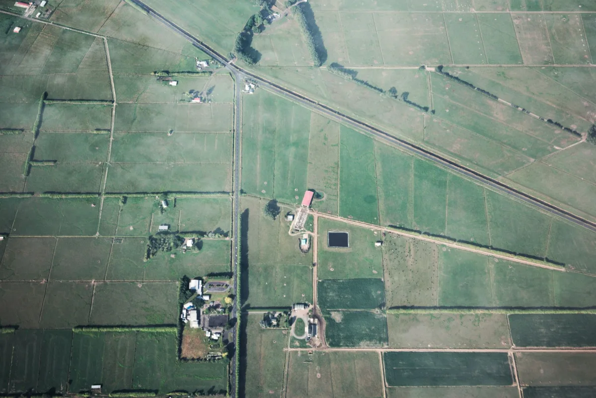 Vista aérea de talhões agrícolas divididos por estradas e cercas, com sede da fazenda ao centro